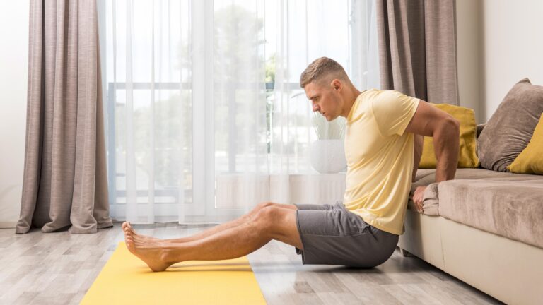 man wearing a yellow shirt doing lower back pain exercises at home using couch