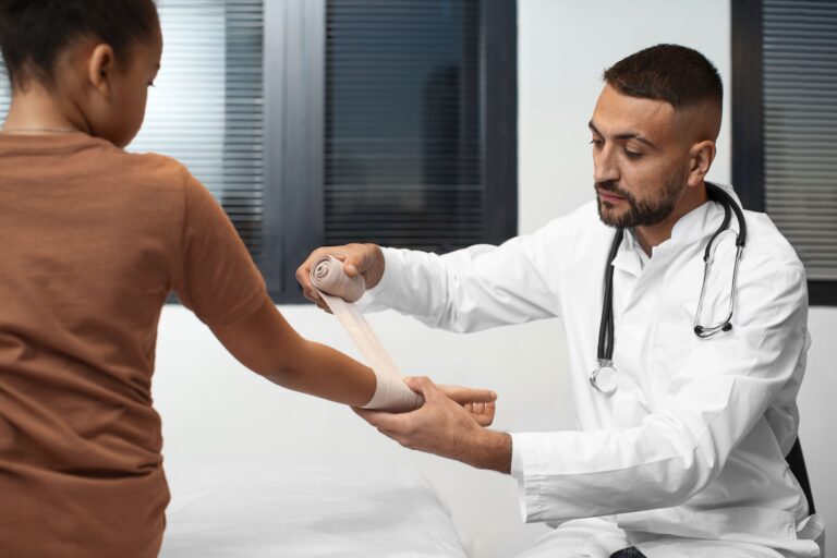 Doctor gently wrapping a bandage around a child’s arm during a medical visit showing careful treatment and emphasizing health disparities in pain treatment