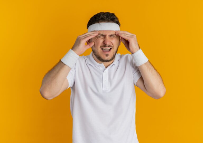Young man pressing temples in pain — nutraceuticals for migraine prevention may help reduce attack frequency