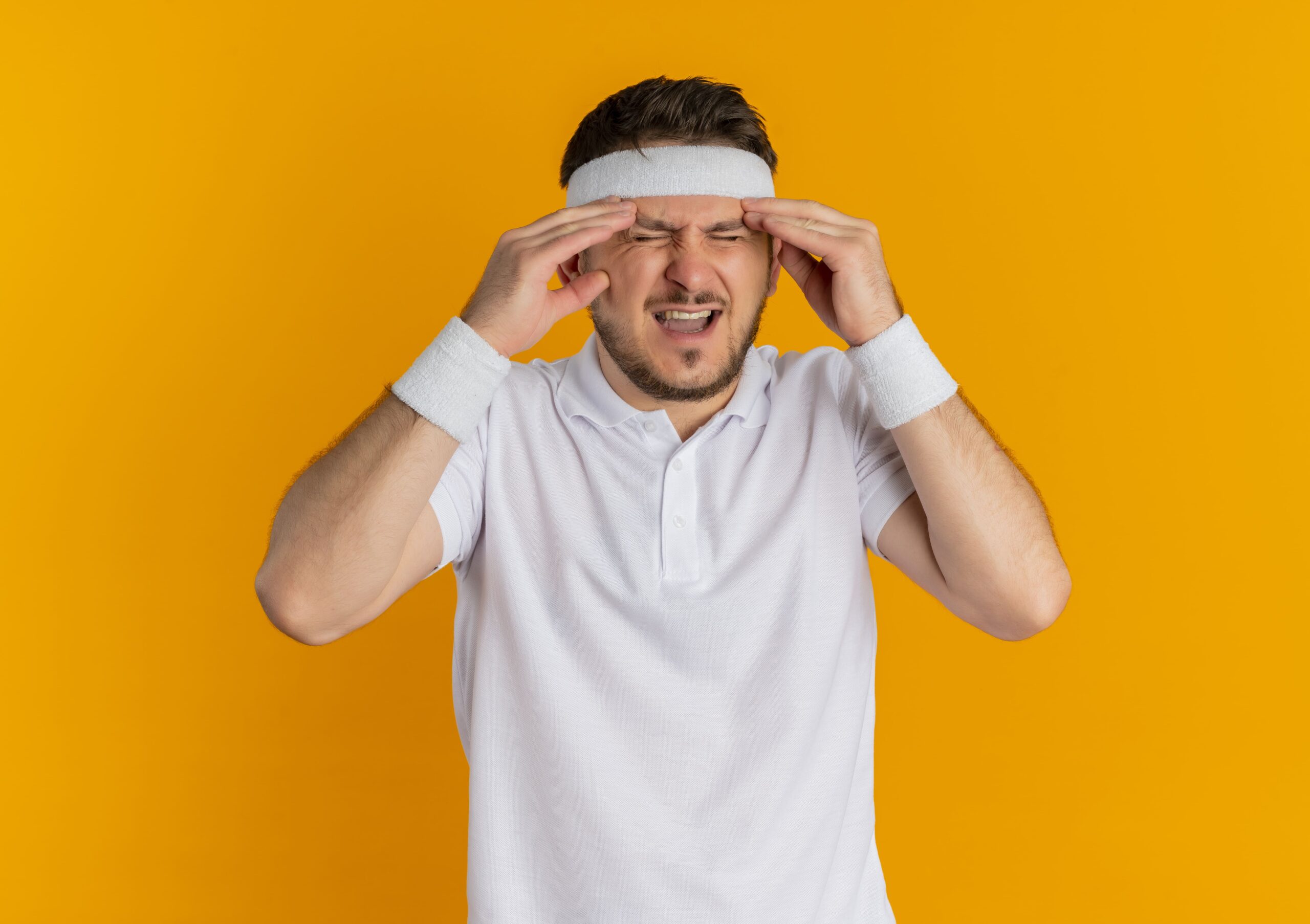 Young man pressing temples in pain — nutraceuticals for migraine prevention may help reduce attack frequency